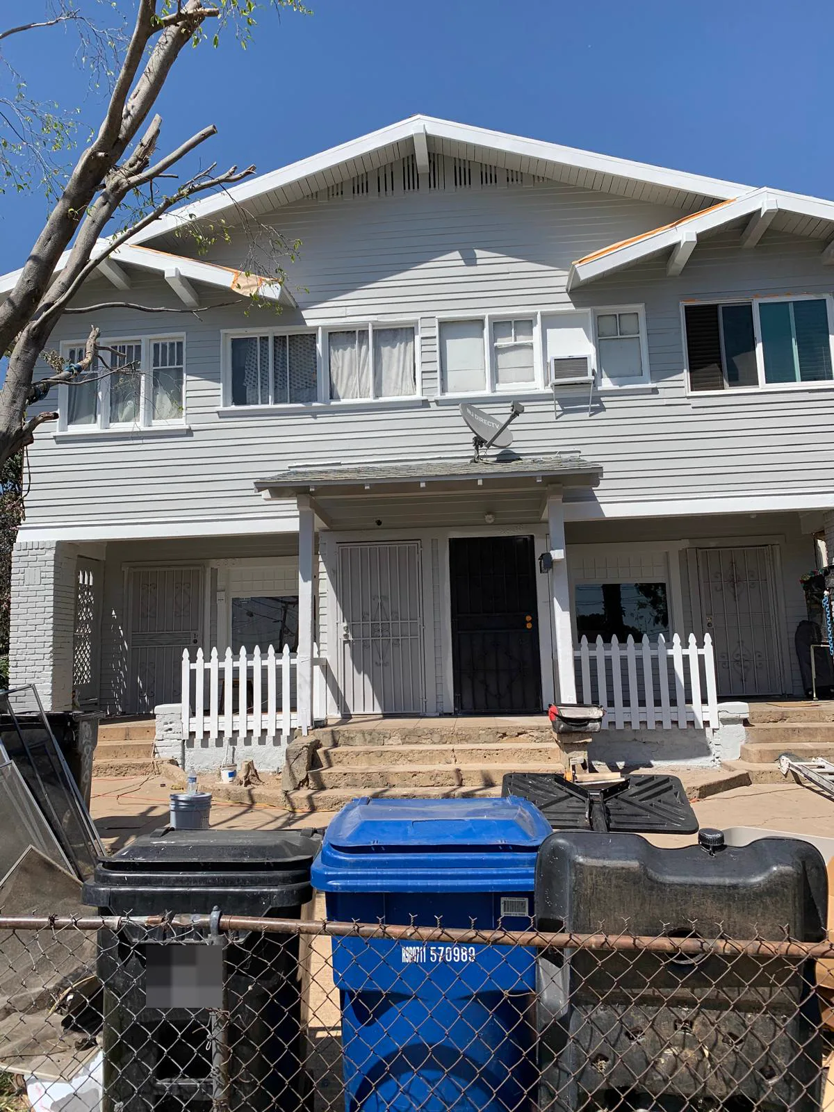 Front porch of the same Alhambra Craftsman in grey with white trim and a white picket rail