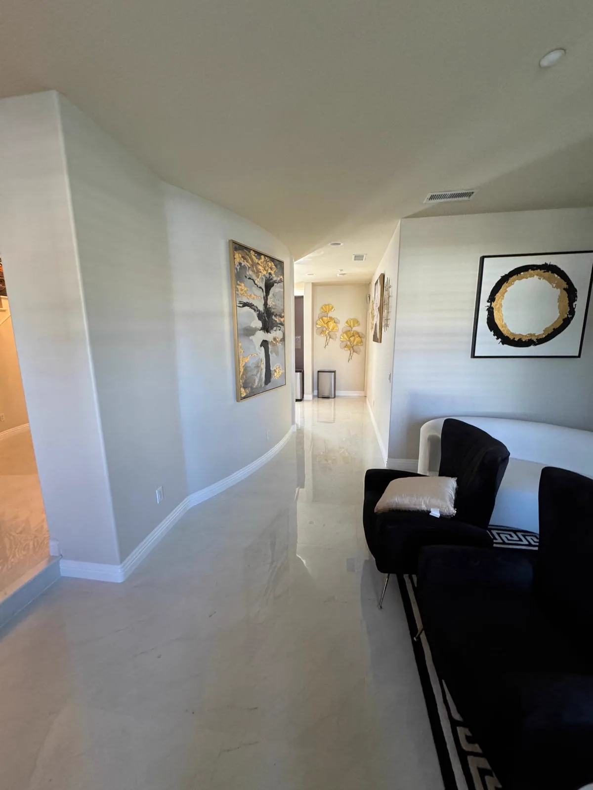 Finished curved hallway in an Alhambra home with white walls and a polished floor