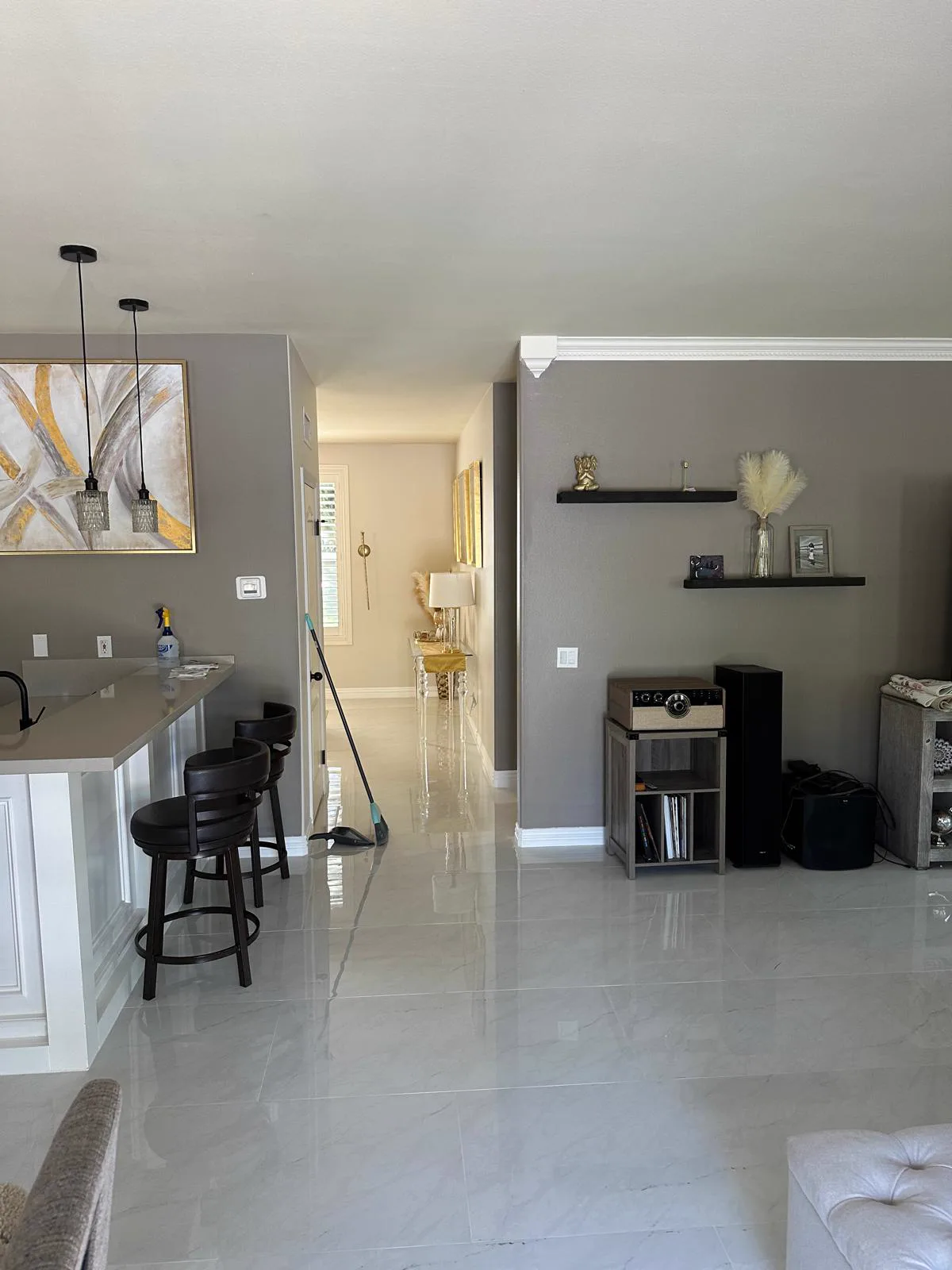 Finished open-plan living area in an Alhambra home with a gray feature wall and white crown molding