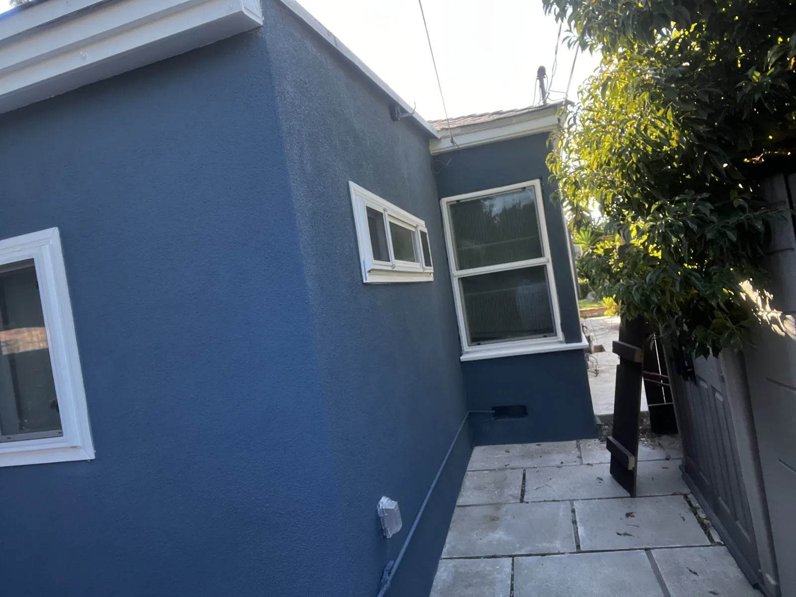 Alhambra stucco home repainted deep navy with white window trim