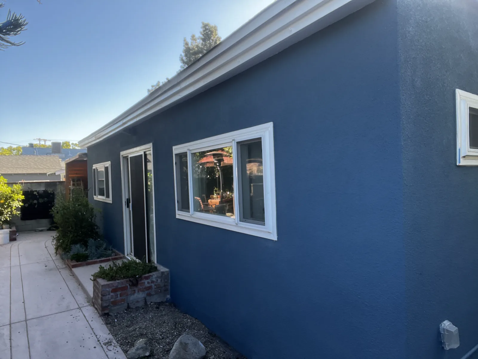 Side elevation of the same Alhambra stucco home in navy with white trim