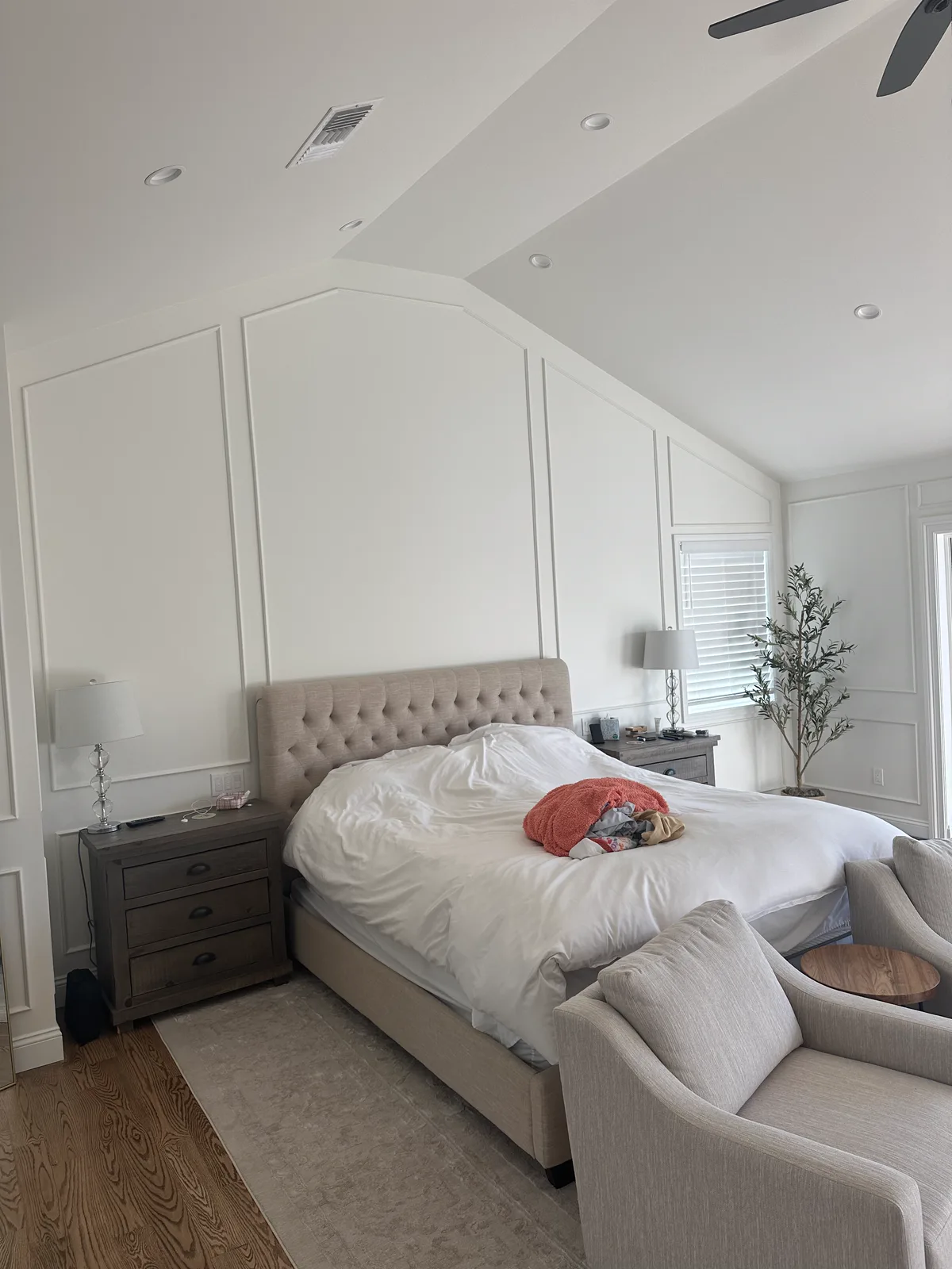Altadena bedroom with white panel moulding walls under a vaulted ceiling