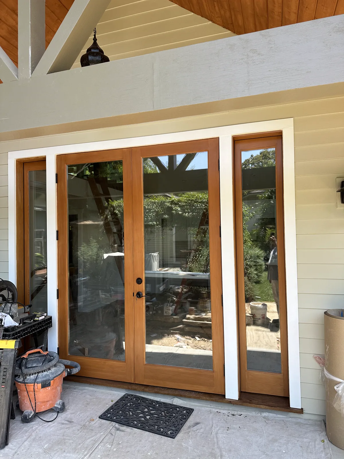 Wood-framed French doors under a beamed patio ceiling at an Arcadia home