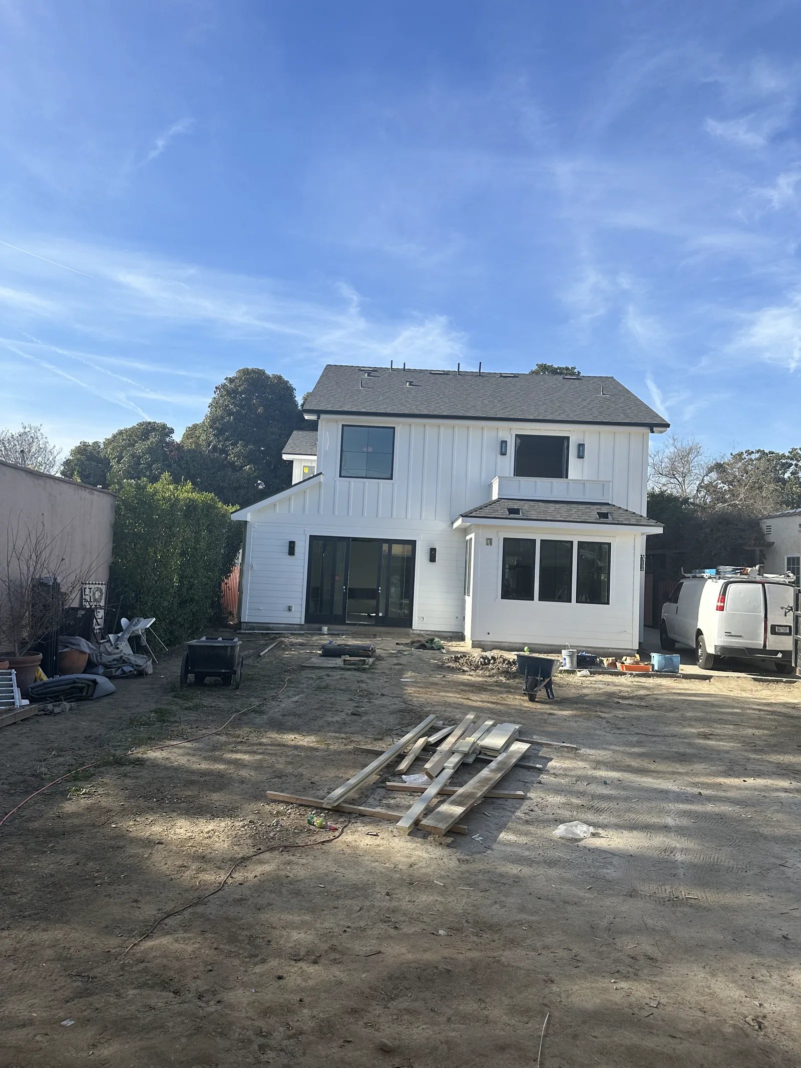 Modern farmhouse rebuild in Arcadia with white board-and-batten siding and black windows
