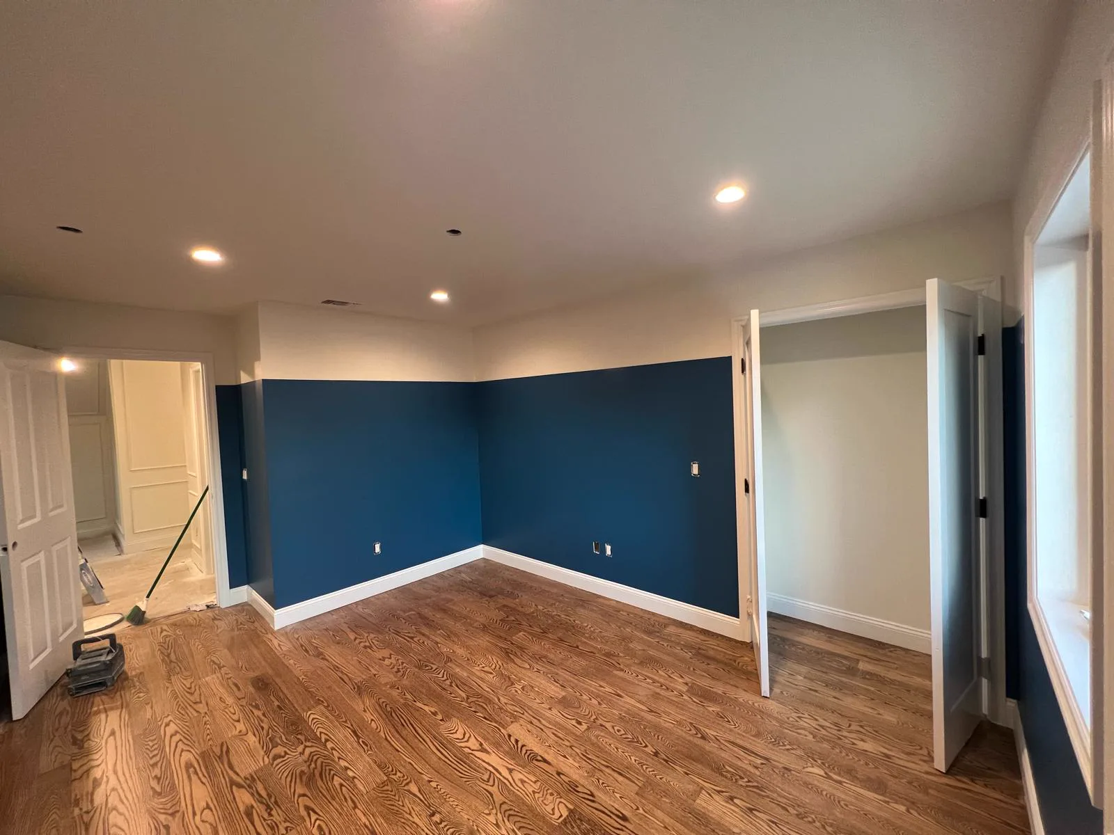 Arcadia bedroom with deep navy accent walls, white trim and oak floors
