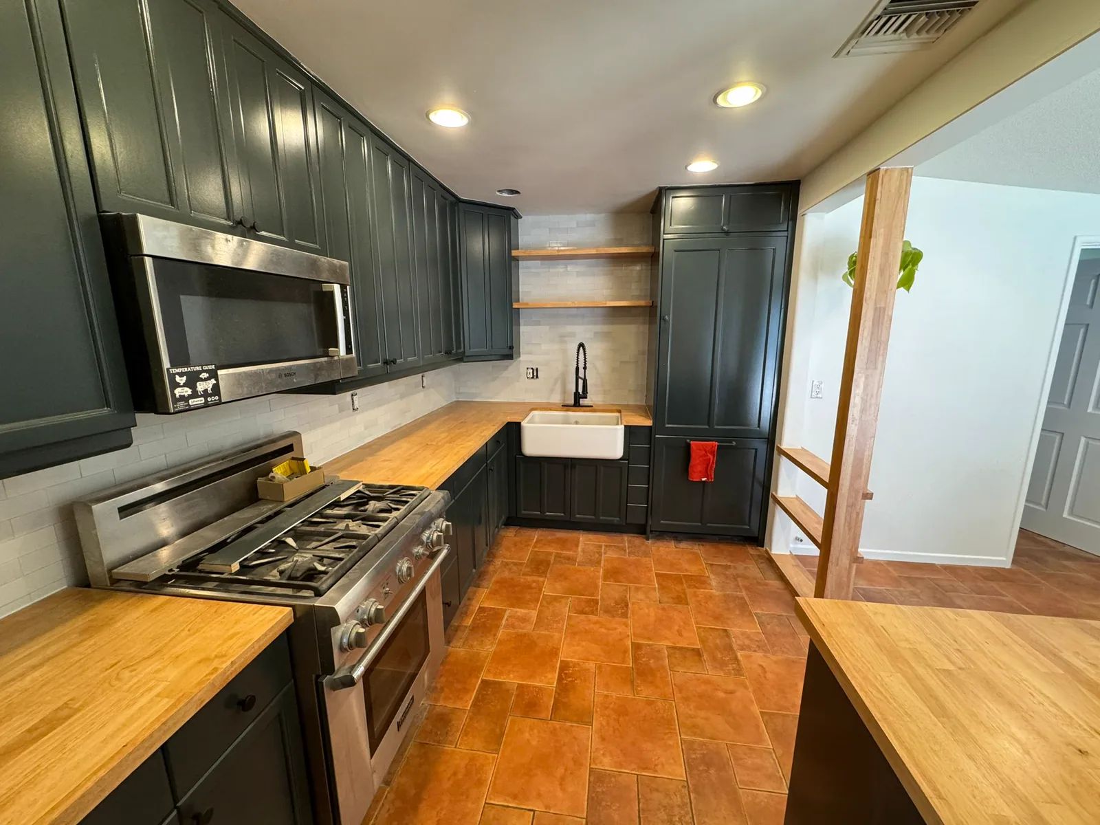 Arcadia kitchen with deep green refinished cabinets, butcher block counters and a farmhouse sink