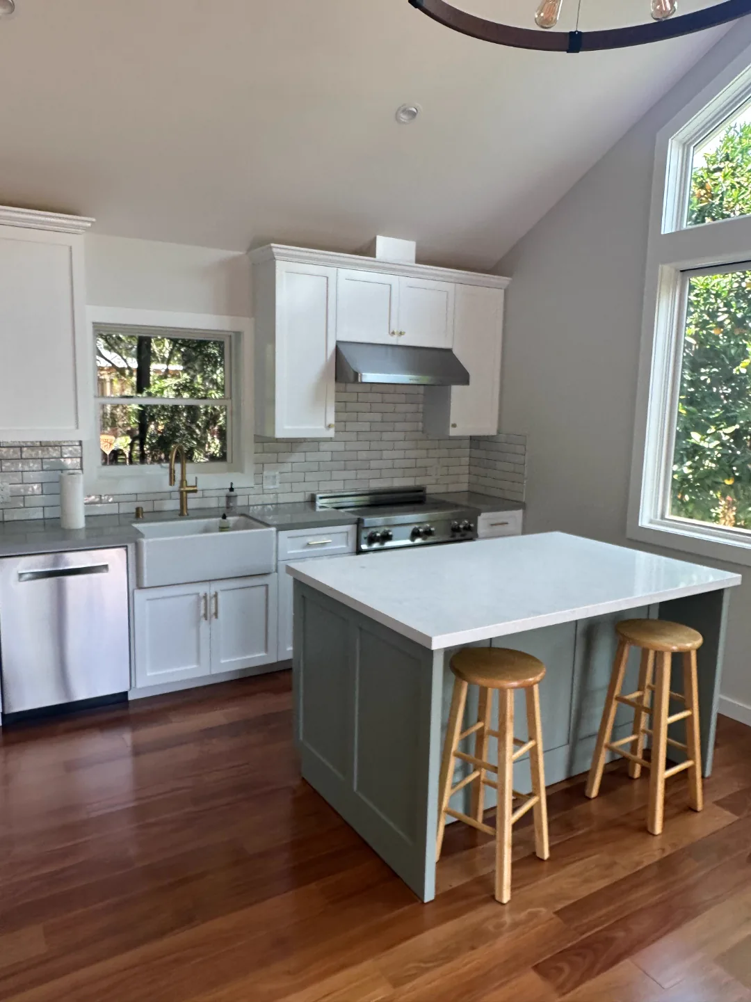 White kitchen cabinets with a sage green island in a Pasadena home