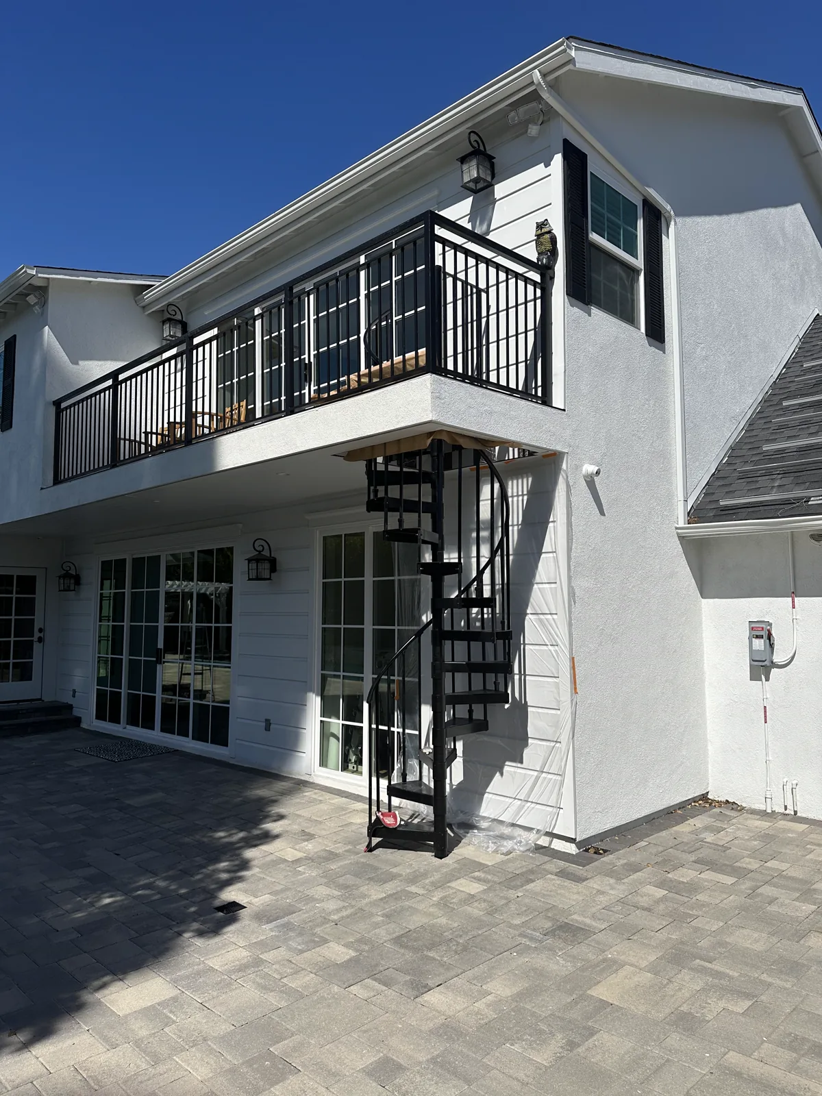White two-story Altadena home with a black balcony rail after exterior repainting