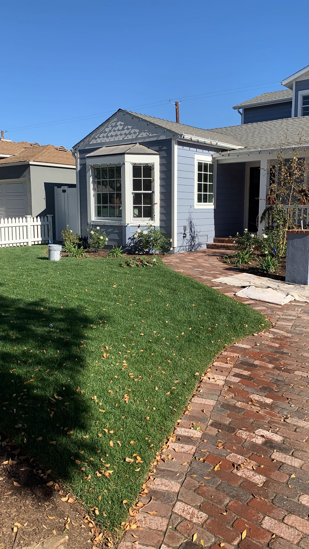 Slate-blue single-story cottage with white trim after exterior repainting