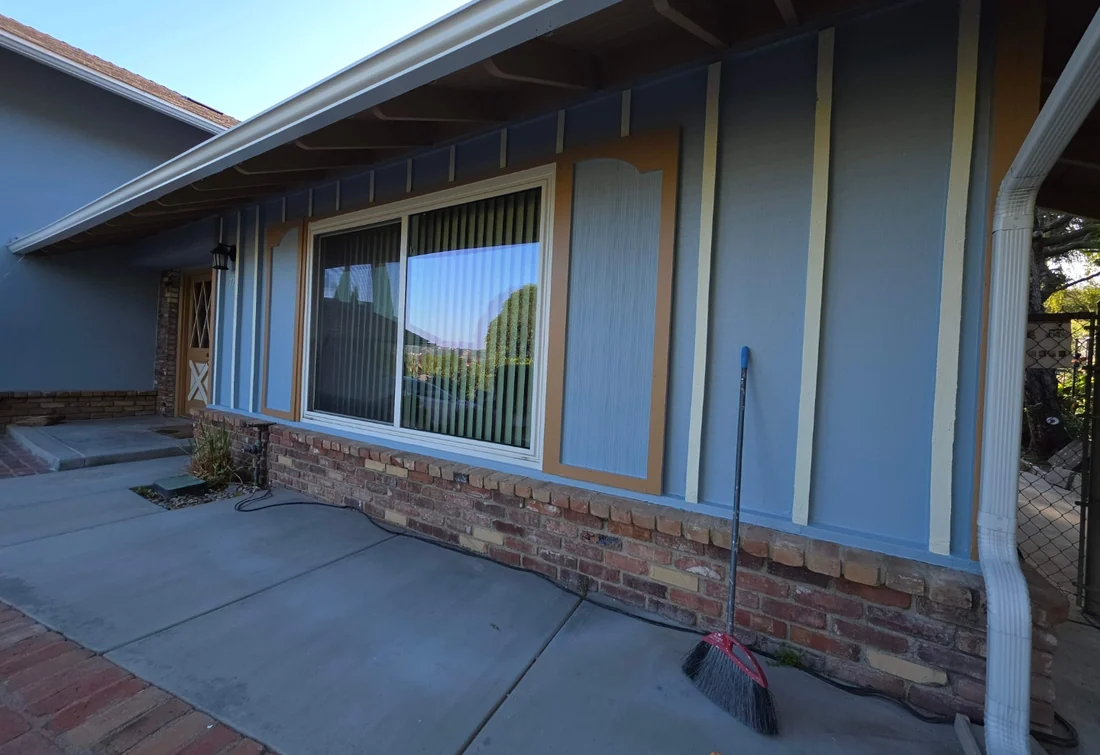 Completed blue-gray home exterior with natural wood detail