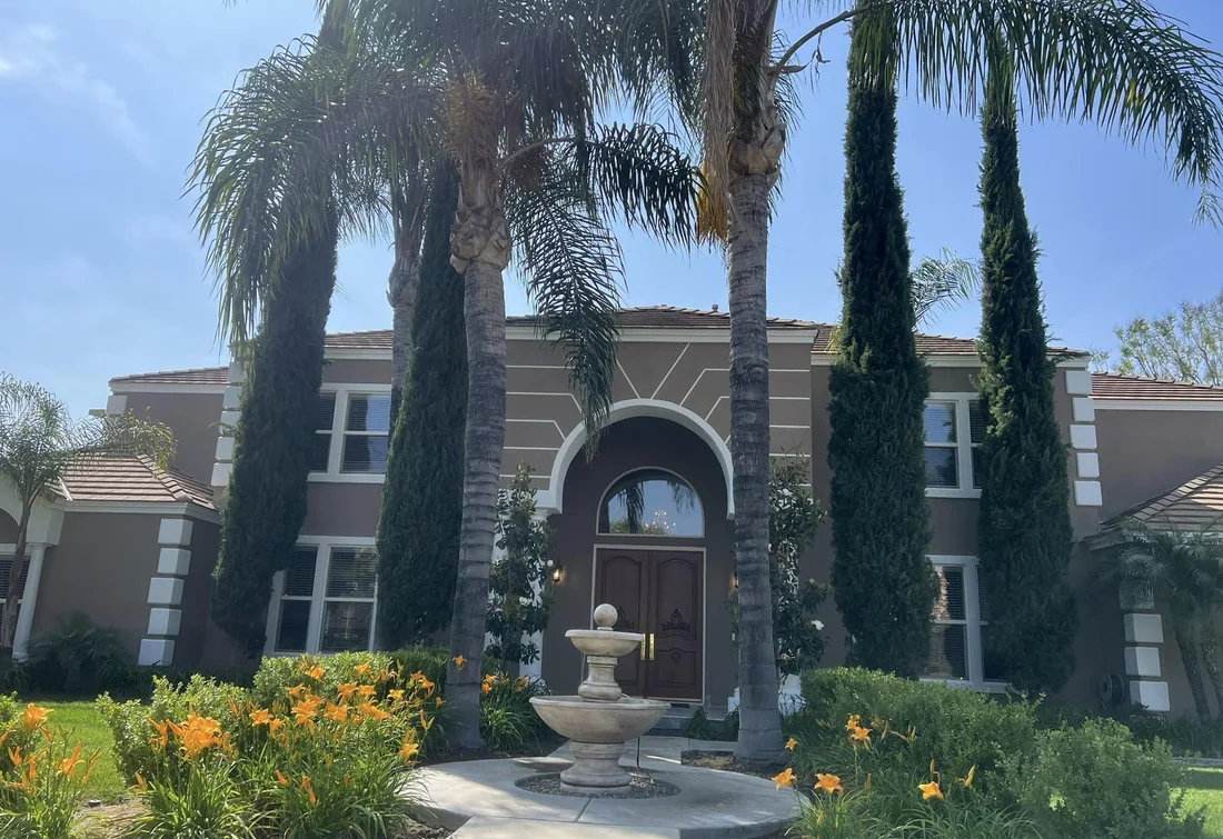 Completed large home exterior painting project with detailed trim