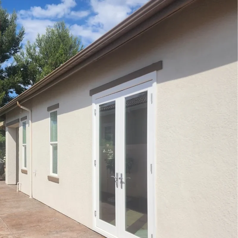 Warm stucco exterior after white and taupe repainting