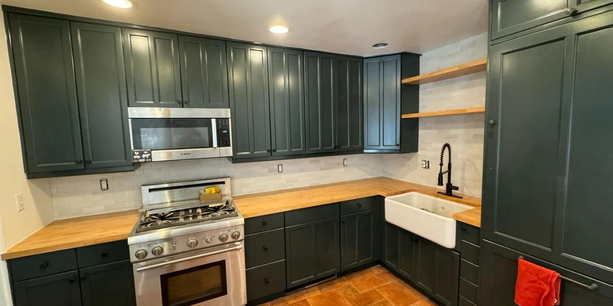 Finished kitchen cabinetry in a deep green paint finish
