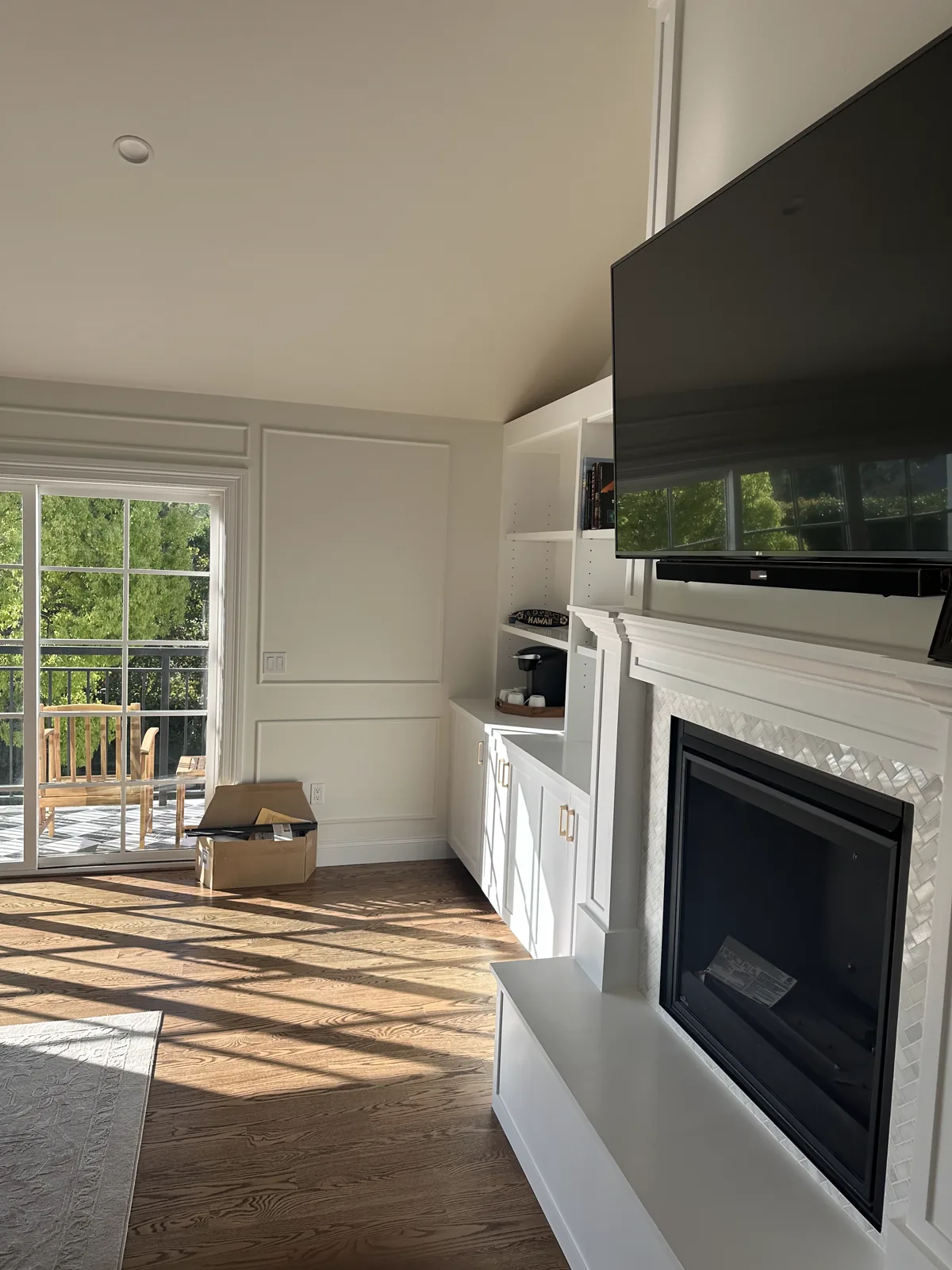 Finished living room in a San Gabriel home with white paneled built-ins and a fireplace