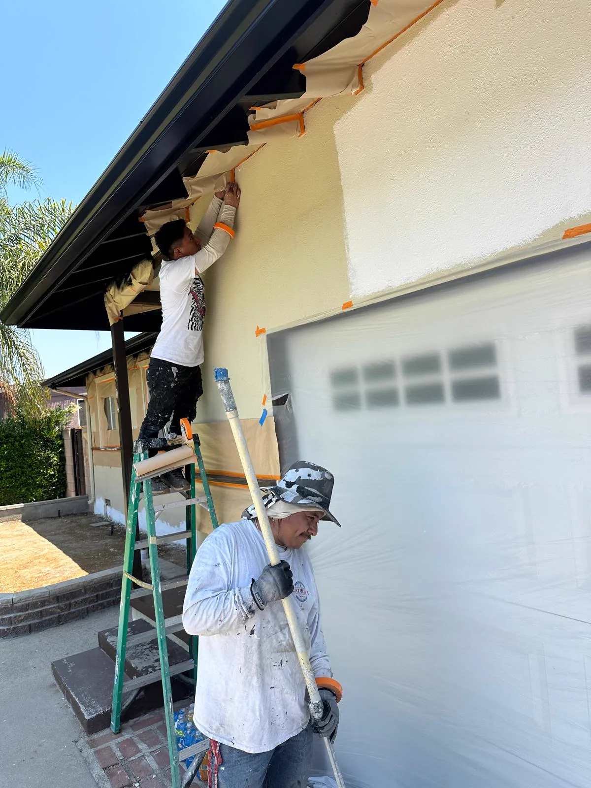 Ivan's Pro Painting crew repainting a house exterior