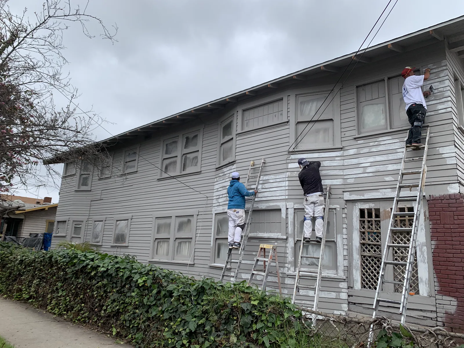 Crew carrying out exterior repair work before painting