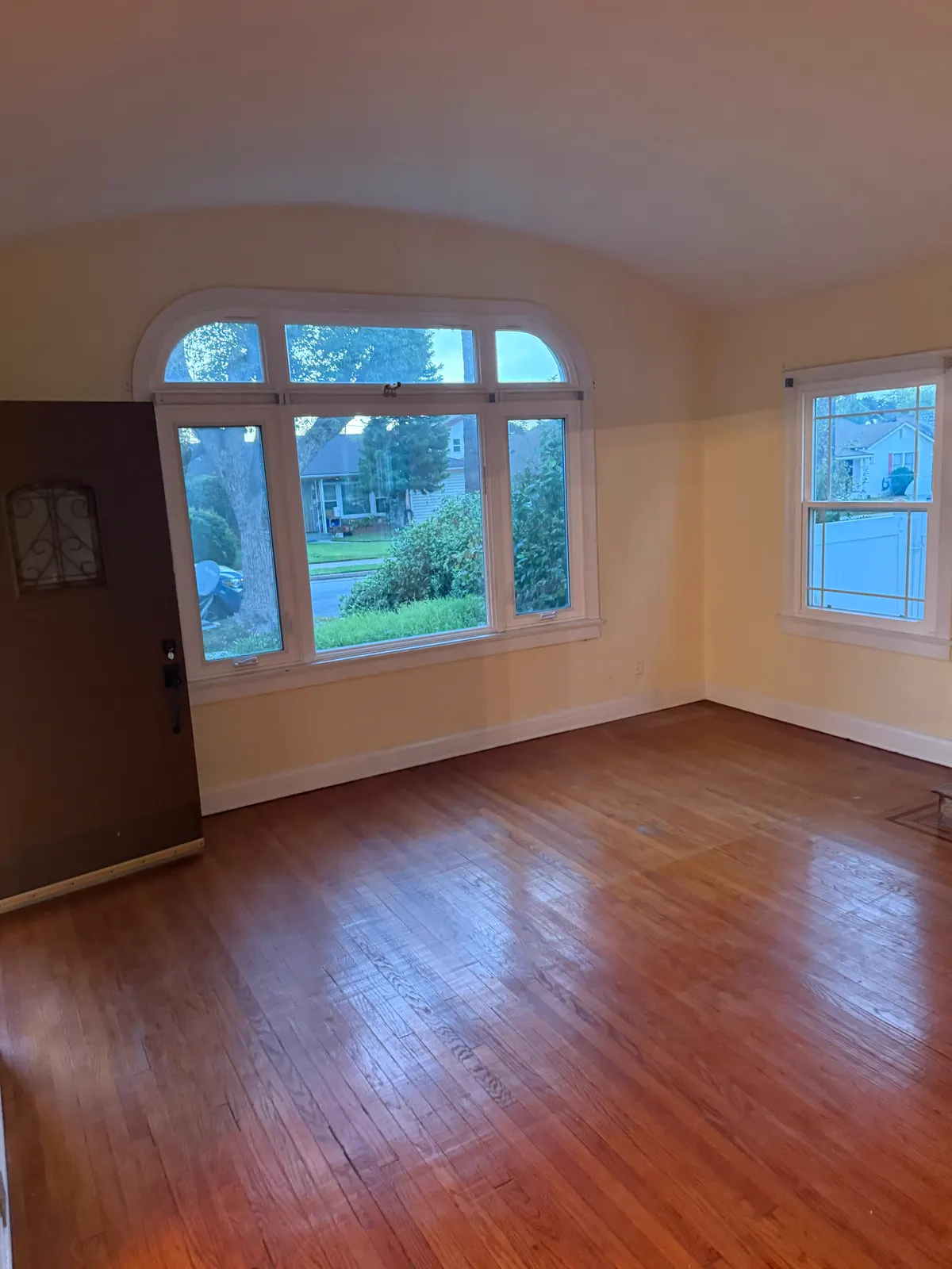 Pasadena living room with plaster walls, a cove ceiling and an arched front window before repair