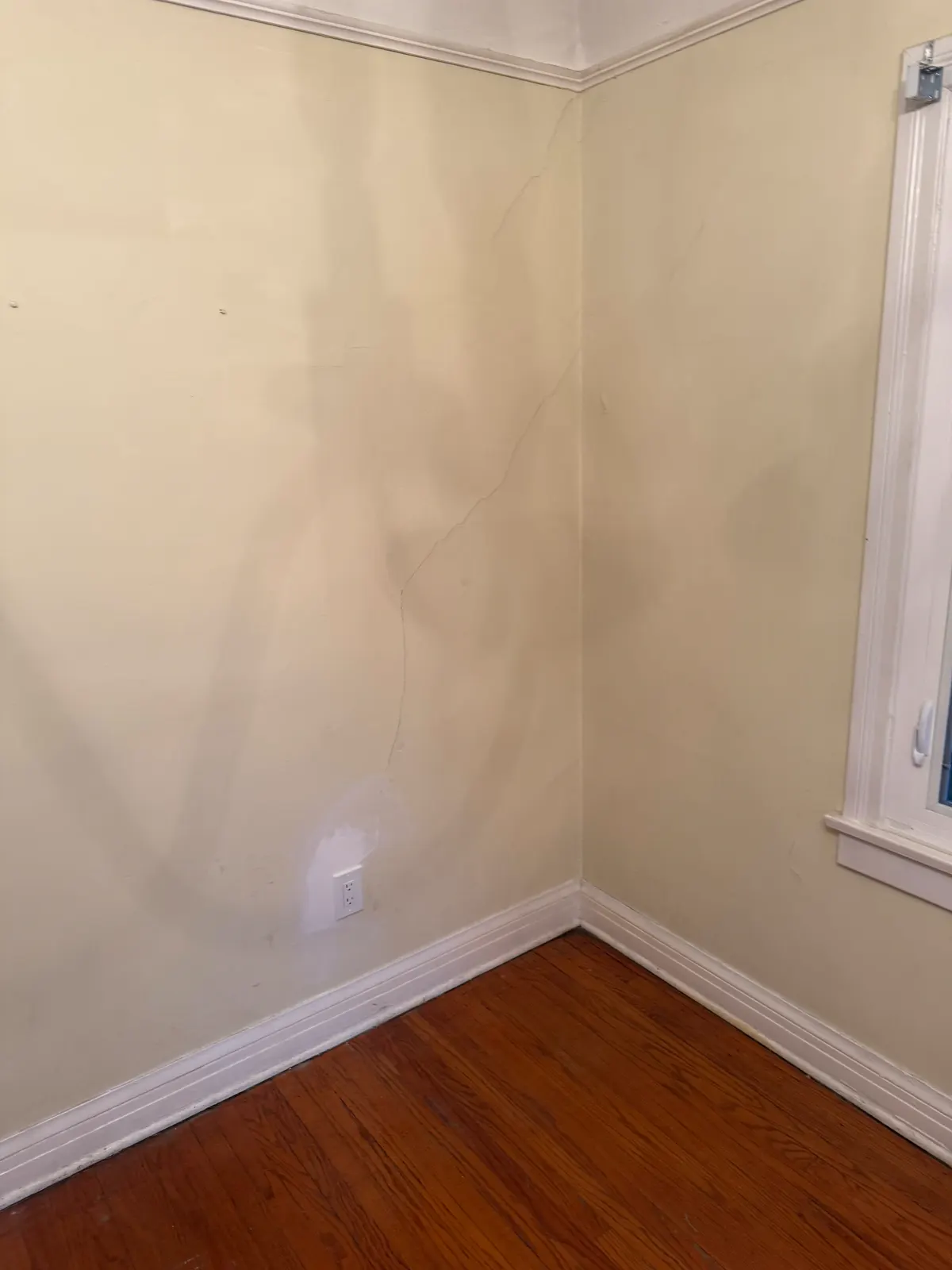 Plaster cracks running into a corner of a Pasadena room before repair