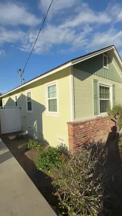 Side of the finished Pasadena ranch, soft green siding above a brick base