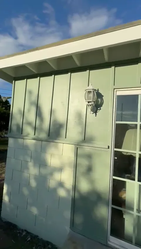 Board-and-batten wall on the Pasadena ranch painted a deeper sage with white eaves