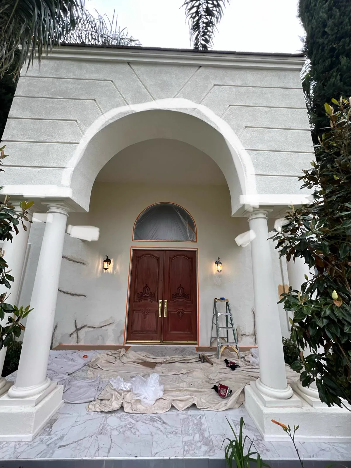 Arched front entry of a South Pasadena home masked and primed before repainting