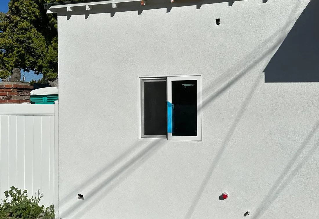 Completed stucco wall repair and white coating