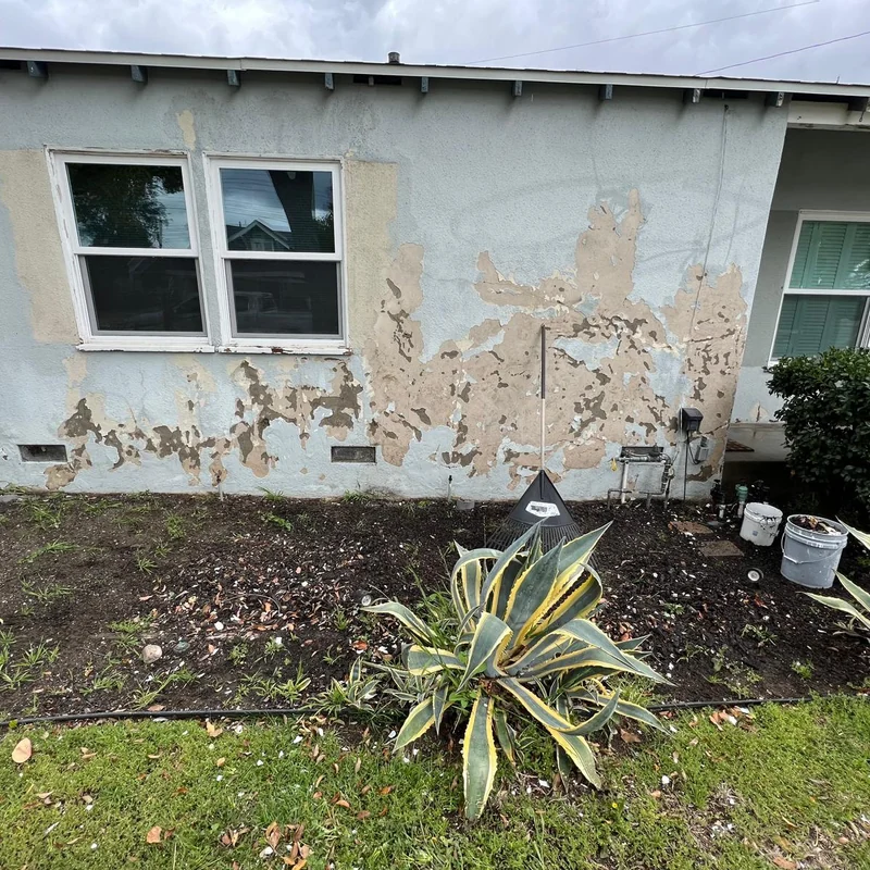 Damaged stucco wall before repair