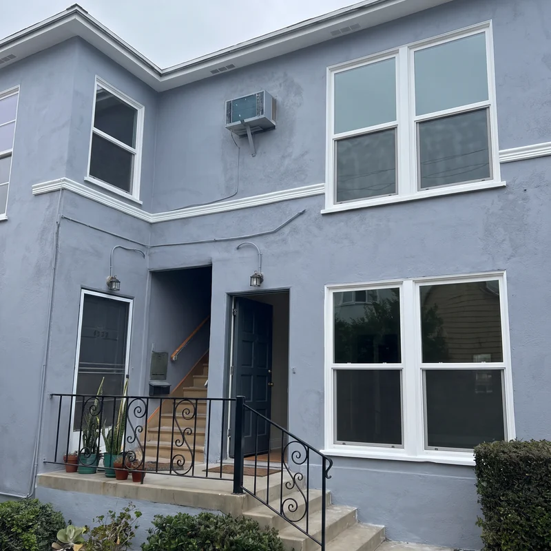 Two-story stucco exterior after blue-gray repainting